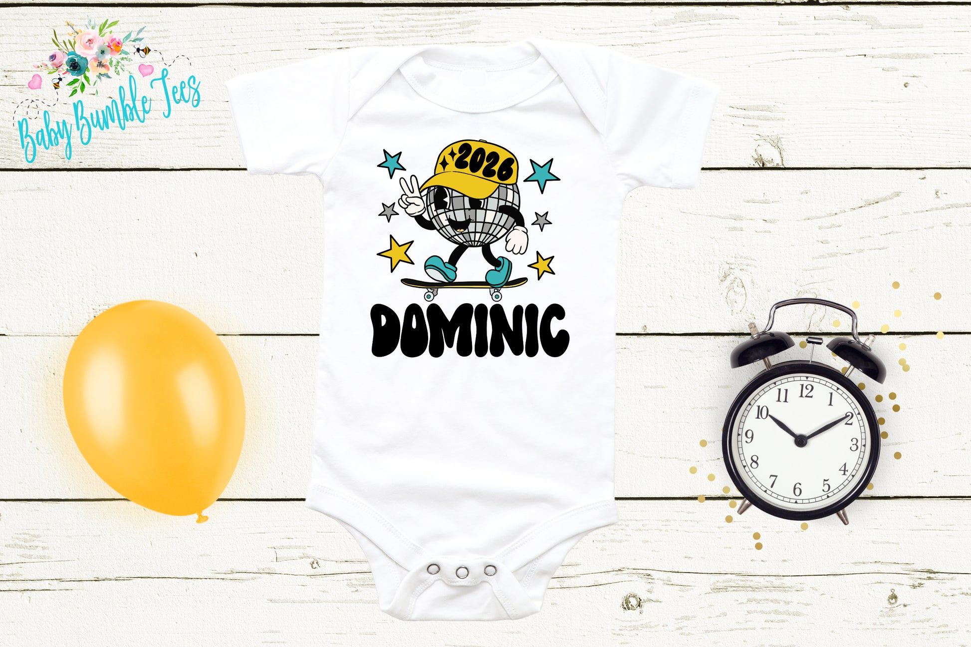 A white baby onesie with a cartoon character on it, a yellow balloon, a black alarm clock, and a floral design on the left side of the image.