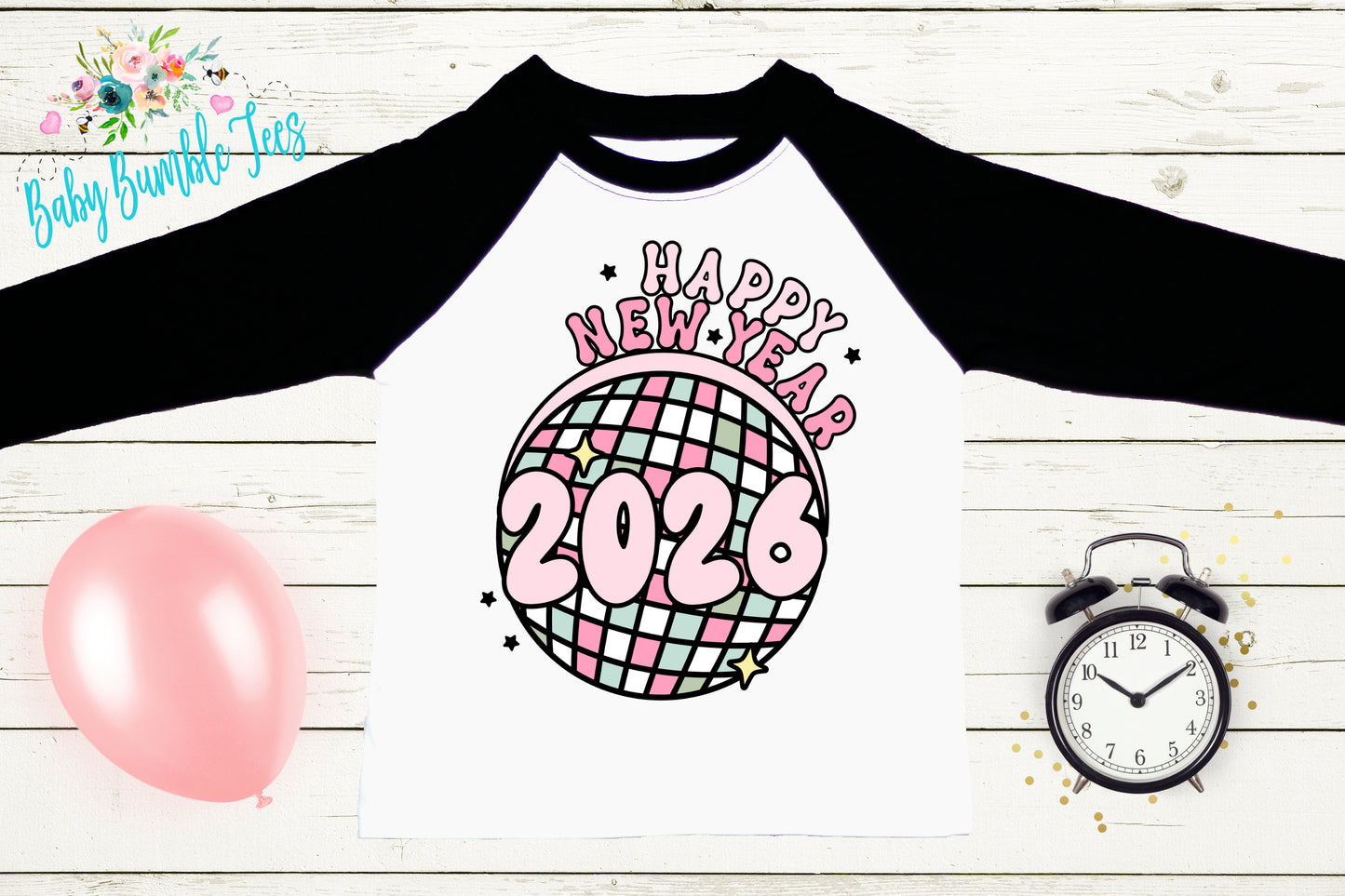 A white t-shirt with a graphic design of a disco ball and the text "Happy New Year 2020" printed on it, along with a black and white alarm clock and a pink balloon.