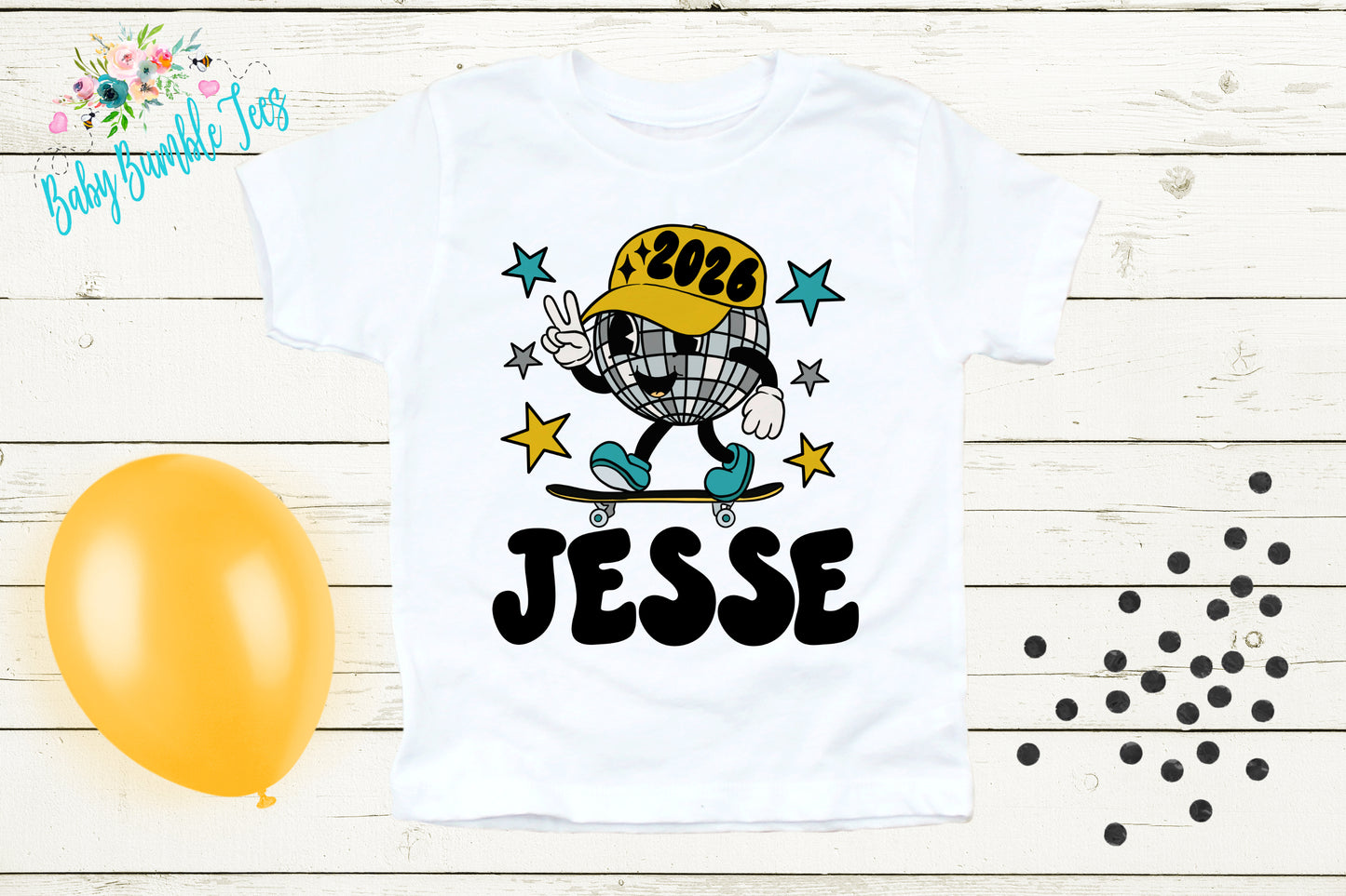 A white t-shirt with a cartoon image of a person riding a skateboard and the name "JESSE" printed on it, along with a disco ball and stars. The t-shirt is displayed on a wooden surface, and there is a yellow balloon and scattered black dots in the background.