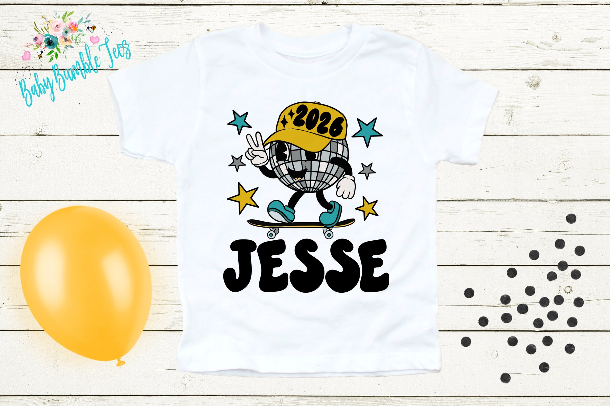 A white t-shirt with a cartoon image of a person riding a skateboard and the name "JESSE" printed on it, along with a disco ball and stars. The t-shirt is displayed on a wooden surface, and there is a yellow balloon and scattered black dots in the background.
