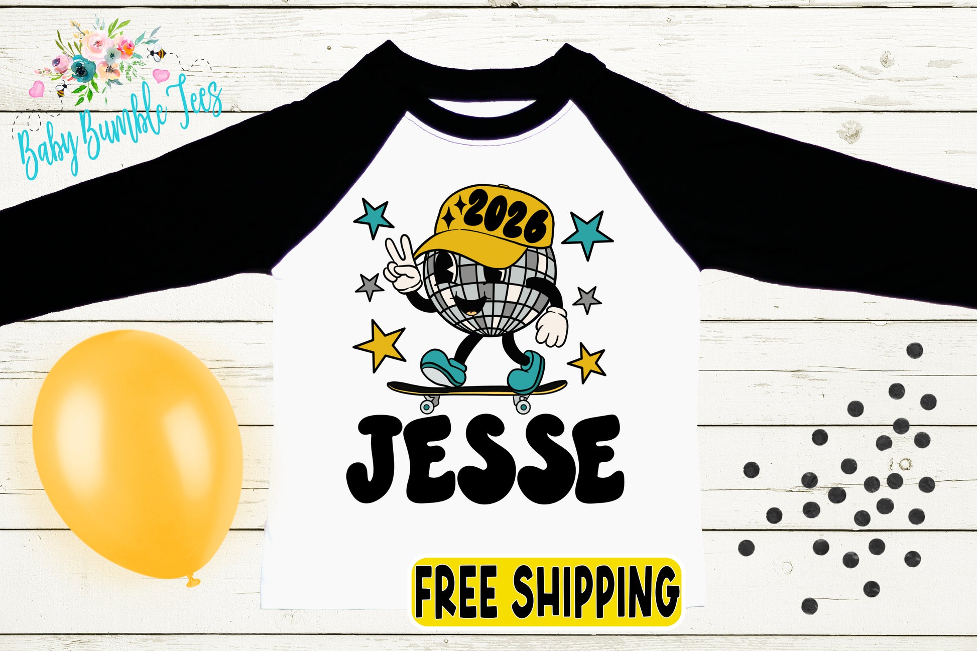 a white and black long-sleeved shirt with a cartoon character on it, along with a yellow balloon and scattered black dots on a wooden background.